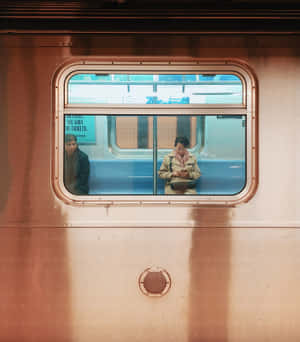透過車窗看到兩名人士坐在火車車廂內