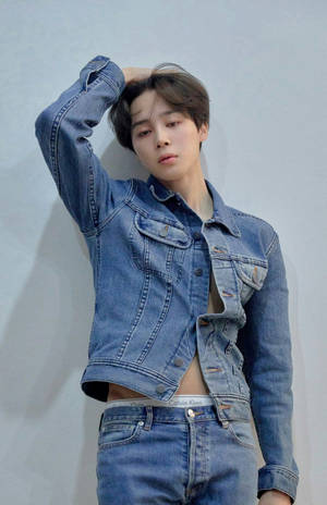 年輕男子身穿牛仔外套和牛仔褲，手放在頭髮上擺姿勢。 — Jimin GIF 壁紙