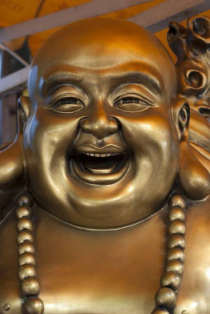戴著珠串項鍊的金色笑佛雕像