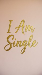 金色草書文字 'I Am Single' 在粉紅色背景上。