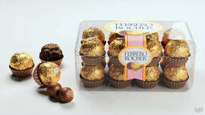 透明盒中的Ferrero Rocher朱古力，白色背景上有散落的榛子。 — 朱古力 壁紙