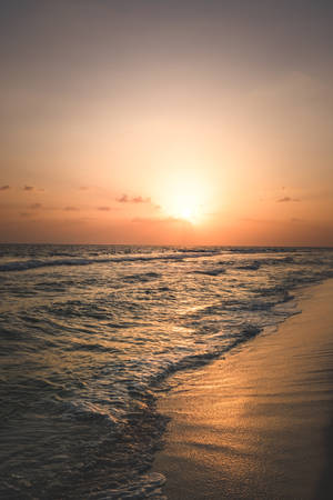夕陽下的海洋，波浪沖刷沙灘 — 日落 壁紙
