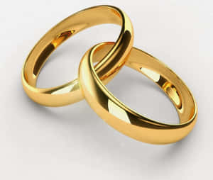 兩枚金色結婚戒指在白色背景上交織。 — 金色 壁紙