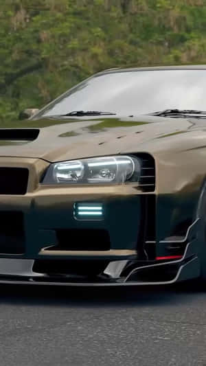金色日產GT-R帶藍色燈光，停在靠近綠樹的道路上。 — 汽車 壁紙
