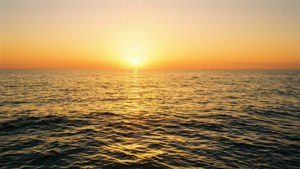 平靜海面上的夕陽，帶有金色倒影