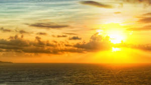 金色雲朵和寧靜海面上的夕陽