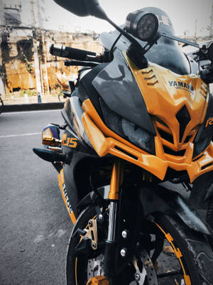 橙色和黑色Yamaha R15運動電單車停泊在城市街道上。