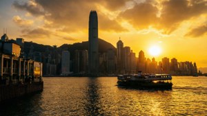渡輪在金色日落中駛過香港天際線。