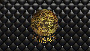 帶有銀色鉚釘的黑色絎縫皮革上的金色 Versace 標誌。