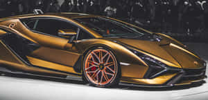 金色林寶堅尼跑車展示，配橙色輪胎，背景模糊人群。