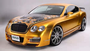 金色賓利 Continental GT，帶有花卉引擎蓋藝術和定制輪圈。 — 汽車 壁紙