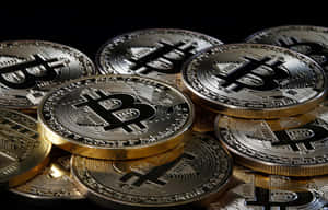一堆金色比特幣，在深色背景上刻有符號。 — 比特幣 壁紙