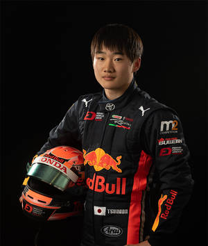 穿著Red Bull Honda裝備的年輕日本賽車手拿著頭盔。