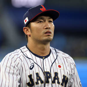 身穿制服的日本棒球運動員在夜間比賽中專注地凝視