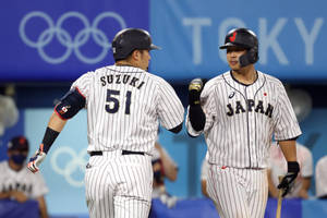日本棒球選手在奧運比賽中擊掌。