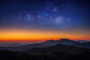 星銀河在暮色中拱形於山脈輪廓之上 — 月色夜空 壁紙
