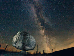星空夜空下的一塊大岩石，銀河可見。