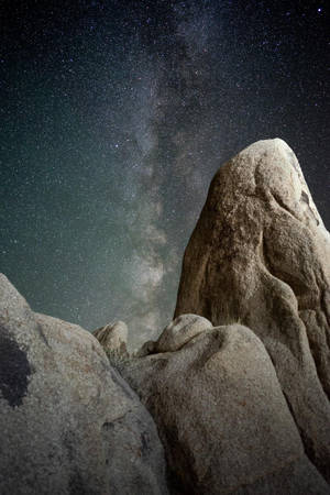 夜晚沙漠岩石層上空的銀河系 — 太空 壁紙