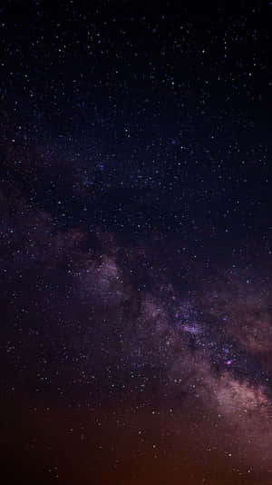 銀河系在繁星點點的夜空中閃耀著紫色和粉紅色的星雲。 — 太空 壁紙