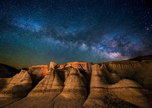 星空之夜，銀河系照亮沙漠岩層。