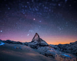 白雪覆蓋嘅山峰喺紫色同橙色色調嘅星空暮色下。