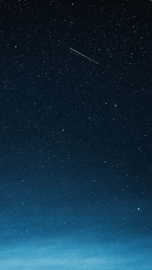 一顆流星劃過深藍色色調的星空夜空。