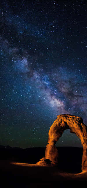 在可見銀河系的星空夜空下，一座發光的石拱門。