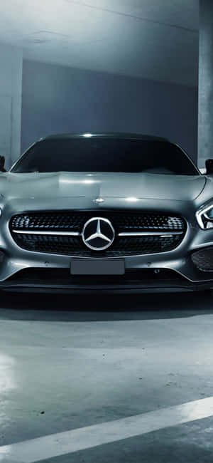 銀色 Mercedes 跑車停放在燈光昏暗的混凝土車庫中。 — Galaxy M17e 壁紙
