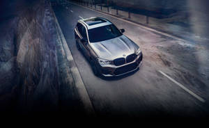 銀色BMW SUV在黃昏時分於山路上高速行駛。