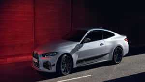 銀色BMW M4雙門轎跑車在夜間停在紅磚牆前。 — 汽車 壁紙