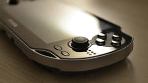 柔和燈光下木質表面上的銀色PlayStation Portable。