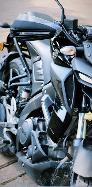 帶有鍍鉻細節的啞光黑色Yamaha電單車停泊在磚砌路面上。