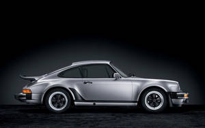 銀色保時捷911 Turbo跑車在攝影棚中配以戲劇性燈光。