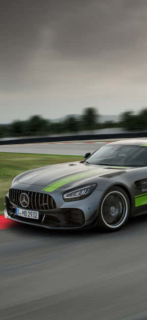 銀色 Mercedes-AMG GT 賽車在潮濕的賽道上快速行駛，帶有綠色條紋。 — Galaxy M16 壁紙