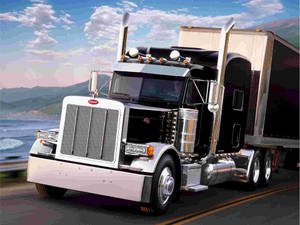 Peterbilt 半掛卡車在日落時分行駛在沿海高速公路上