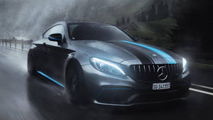 帶有藍色點綴的銀色 Mercedes-AMG 在夜間雨中山路飛馳。