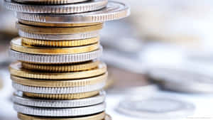 高聳的金幣和銀幣堆，背景有模糊的硬幣。 — 金色美學 GIF 壁紙