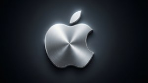閃亮的拉絲金屬 Apple 標誌在深色背景上發出柔和光芒