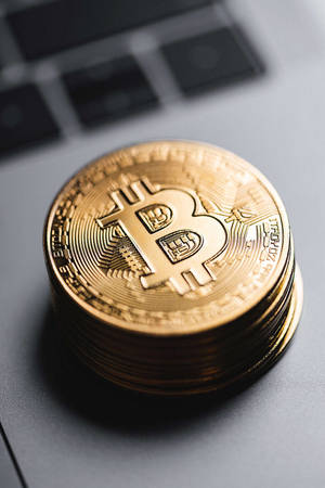 電腦鍵盤上的一堆金色比特幣硬幣。