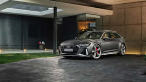 啞光灰色奧迪 RS 6 Avant 夜間停在現代混凝土結構下。