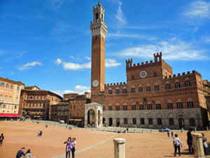 遊客在明亮的藍天下探索錫耶納歷史悠久的Piazza del Campo。 — 意大利卡普里 壁紙