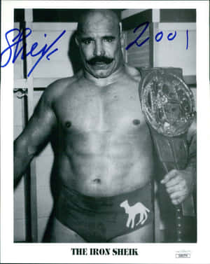 The Iron Sheik 在一張簽名黑白照片中手持摔角冠軍腰帶。 — 摔角 GIF 壁紙