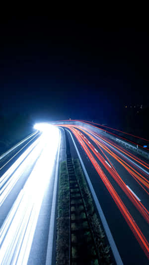 夜間高速公路，帶有移動的白色和紅色車燈軌跡。