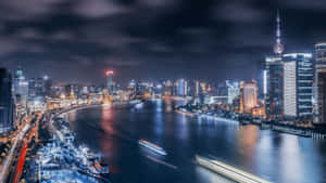 夜間城市天際線，河上有發光的建築物和船隻。