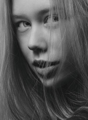 年輕女性的黑白特寫肖像，頭髮勾勒臉部輪廓。
