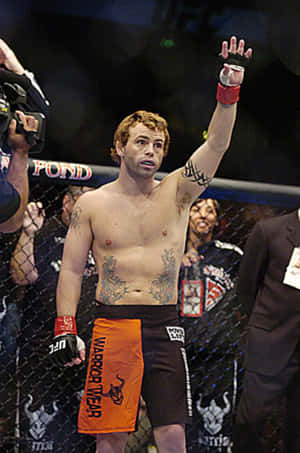 MMA拳手在八角籠內舉手慶祝勝利。