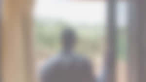 模糊人影站在門口望向外面綠色。