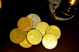 一堆金色加密貨幣硬幣，附近有一個木槌。