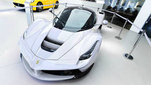 白色法拉利LaFerrari在豪華汽車展廳中展示，後面有一輛黃色法拉利。