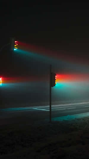 交通燈在結霜的夜間道路上透過霧氣發出紅色和青色的光芒。 — 黃色 壁紙
